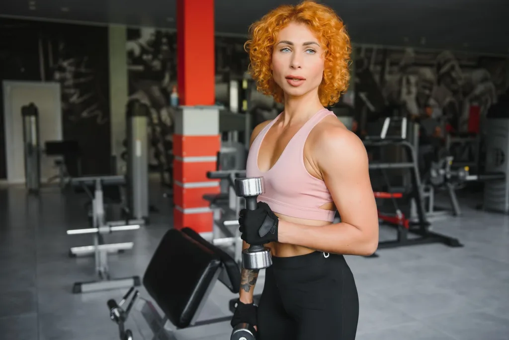 female with orange hair lifting a dumbell