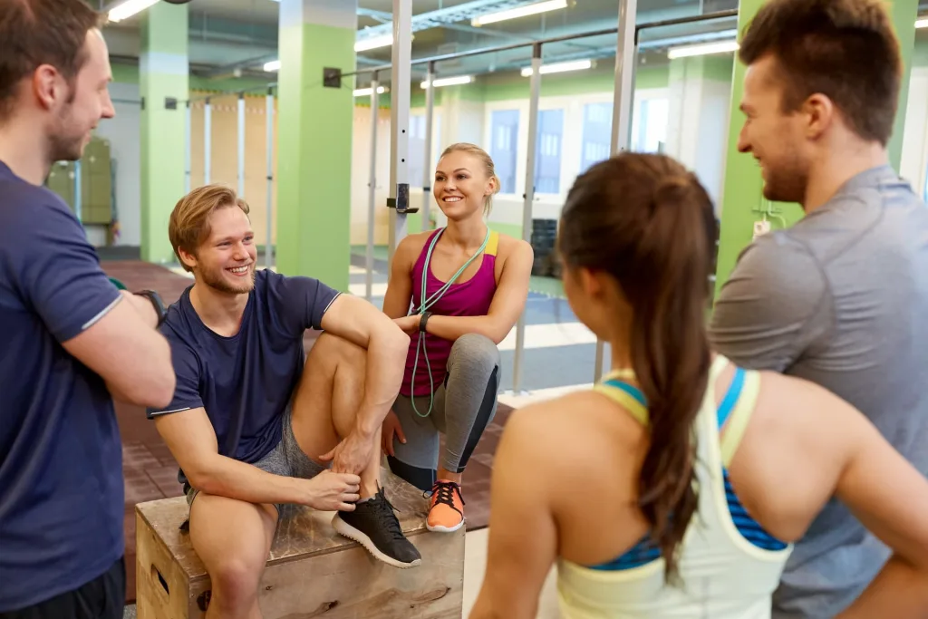 group laughing with each other inside a gym