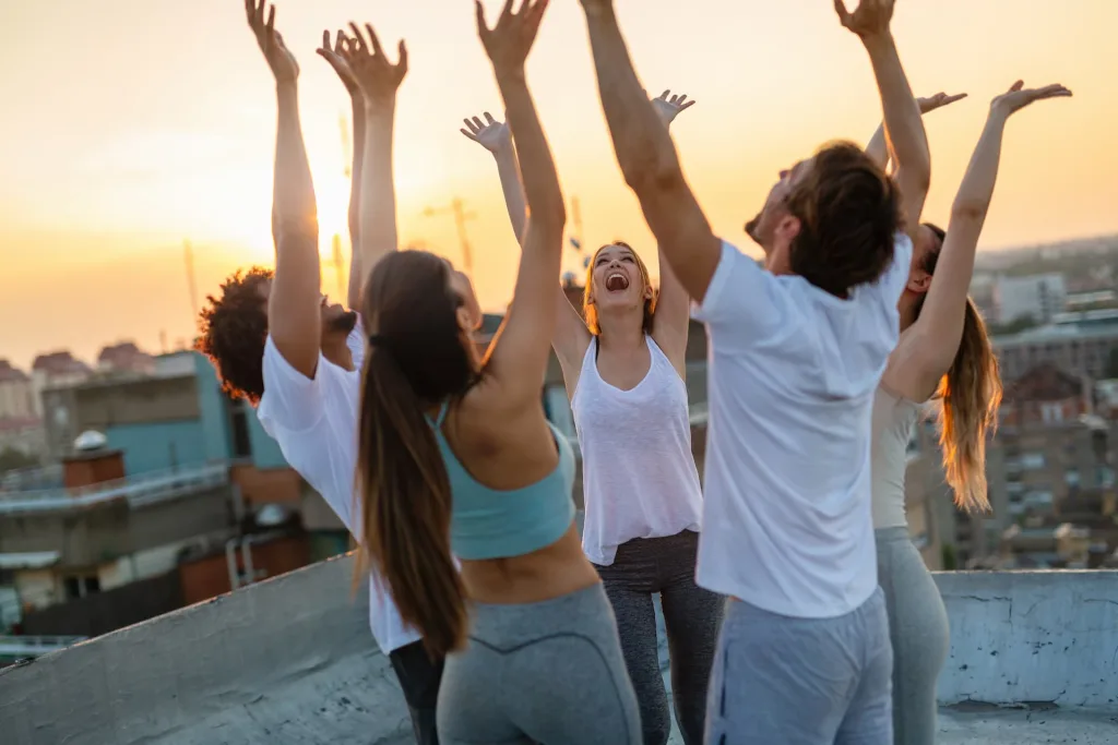 group working out and raising their hands happy